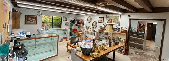 Inside the Erica's Place shop: glass display counters, shelves of decor and collectibles, and framed art on the walls