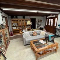 A sofa, coffee table and lamps set up like a living room in the shop