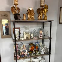 Shelves of gold candlesticks, figurines and glass pieces
